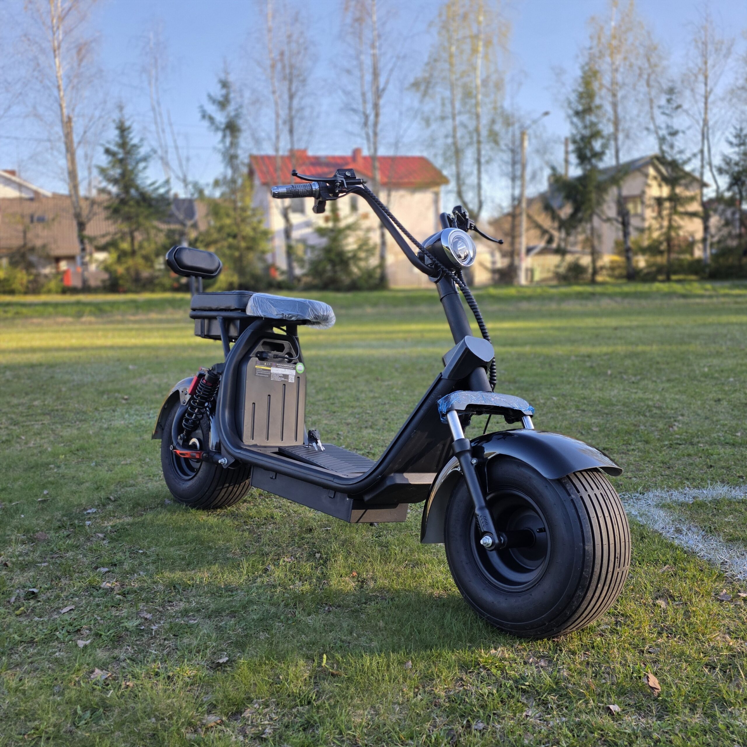 Juodas elektrinis CityCoco motoroleris su dviguba sėdyne ir šoniniu krepšiu daiktams