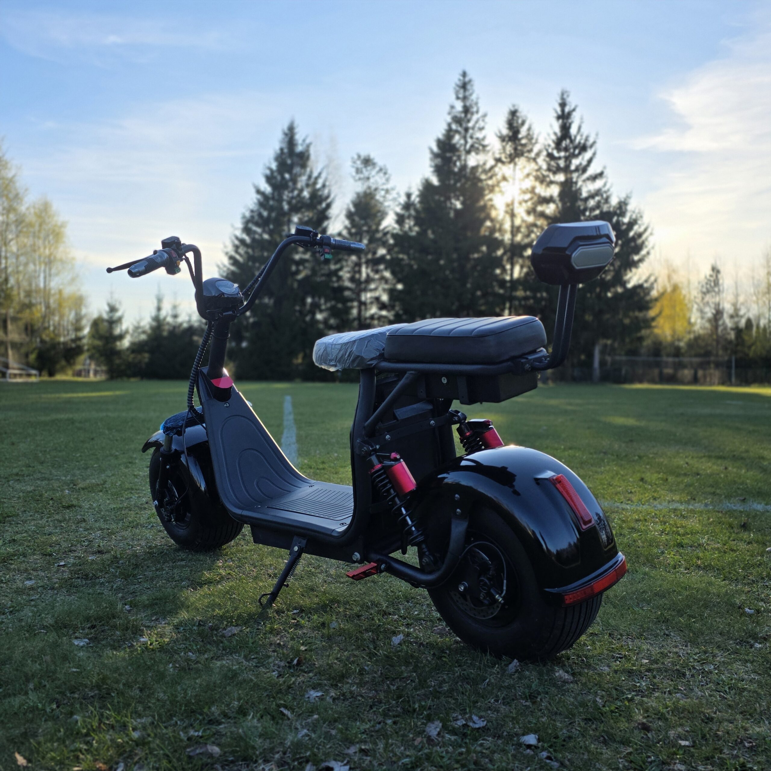 Juodo elektrinio CityCoco motorolerio galinis vaizdas su matomais žibintais ir sėdynės atlošu